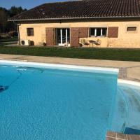 a large blue swimming pool in front of a house at Les Vieille tuiles, Cudos