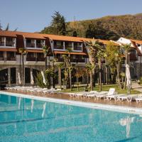 a hotel with a large swimming pool with lounge chairs at Hotel Abaata, Gagra