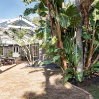 a garden with a greenhouse and palm trees at Yallingup Lodge Spa Retreat