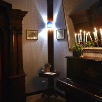 a room with a piano and a mirror with lit candles at Il Confessionale, Castelnuovo di Porto