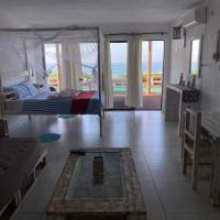 a bedroom with a bed and a view of the ocean at Baleia Azul 14, Ponta Mamoli