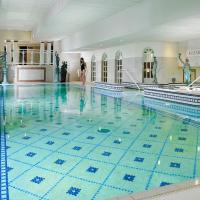 a swimming pool with a woman standing in the middle of it at Killarney Towers Hotel & Leisure Centre