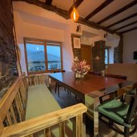 a dining room with a table and a stone wall at Casa Osu Pardo VuT, Caboalles de Abajo