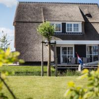 Thatched villa with lounge set, right at the water, hotel in Delfstrahuizen