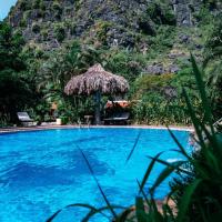 a resort swimming pool with a mountain in the background at Mua Caves Ecolodge (Hang Mua), Ninh Binh