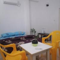 a room with a table and yellow chairs at The Rose Garden House, Hithadhoo