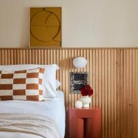 a bedroom with a bed and a red table with a lamp at The Isla, Batemans Bay