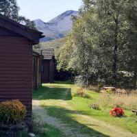 a yard with a house and a mountain in the background at Kinlochewe Mountain Chalets - Chalet 5, Beech