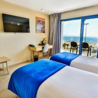 a hotel room with two beds and a view of the ocean at Hotel Cote ocean Mogador, Essaouira