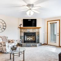 a living room with a fireplace and a ceiling fan at Lighthouse Cove Condo Resort, Wisconsin Dells