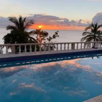 a swimming pool with a sunset in the background at Oceanfront 3 bedrooms, 4beds, AC, WiFi, luxury villa, Woodlands