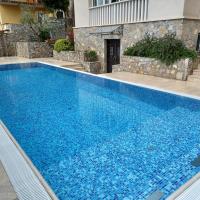 a swimming pool with blue water in front of a house at Abalone Hotel Dramalj, Crikvenica