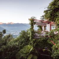 a building covered in ivy with mountains in the background at Relais & Chateaux Hotel Castel Fragsburg, Merano