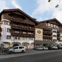 a large building with cars parked in front of it at Das Kaltschmid - Familotel Tirol, Seefeld in Tirol