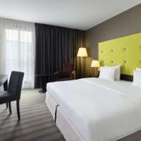 a hotel room with a large white bed and a desk at Radisson Blu Sobieski, Warsaw
