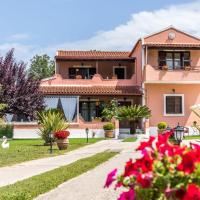 a pink house with flowers in front of it at Areti Apartment, Áfra