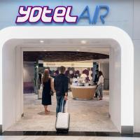 a man and a woman with a suitcase walking into a store at YOTELAIR Singapore Changi Airport Landside