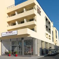 a large white building with a parking lot at Airotel Patras Smart Hotel