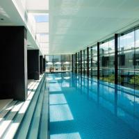 a large swimming pool in a building with glass windows at Crown Promenade Melbourne