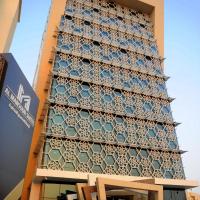 a tall building with blue and white tiles on it at Al Mansour Suites Hotel, Doha