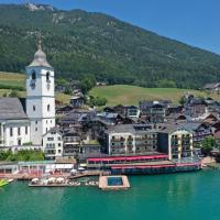 a town on the water with a clock tower at Romantik Hotel Im Weissen Rössl am Wolfgangsee, St. Wolfgang