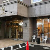 a building with two chairs and a table in front of it at Toyoko Inn Aizuwakamatsu Ekimae