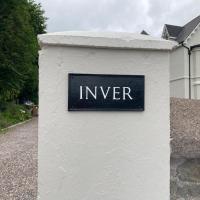 a sign on a white wall in front of a house at Inver, Cobh