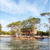 a house on a small island in the water at Hostel villa luz Beach, Tintipan Island