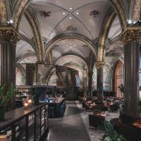 a restaurant with ornate ceilings and tables and chairs at Bergen Børs Hotel