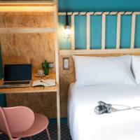 a bedroom with a bed and a desk with a laptop at Birgit Hôtel Le Havre Centre