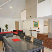 a dining room and living room with a glass table at Osprey Holiday Village Unit 104 - Luxurious 3 Bedroom Holiday Villa with a Pool in the Complex, Exmouth