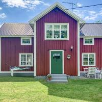 a red house with a green door on a yard at Three-Bedroom Holiday Home in Vimmerby