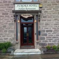 a building with a wooden door with a sign above it at Aurora Hotel & Italian Restaurant, Nairn