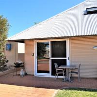 a patio with a table and chairs in front of a house at Osprey Holiday Village Unit 103-1 Bedroom - Cosy 1 Bedroom Studio Apartment with a Pool in the Complex, Exmouth