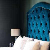 a bed with a blue headboard in a bedroom at Magmell Townhouse, Wicklow