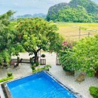 a person swimming in a swimming pool in a resort at Tam Coc Sunshine Homestay, Ninh Binh