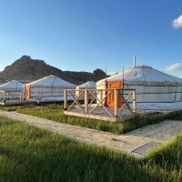 a row of domes in a field of grass at Takhi Resort, Yoliin Hural
