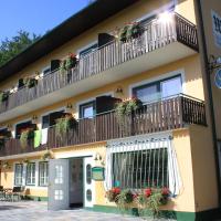 a building with balconies with flowers on it at Pension Waldhof am Stubenbergsee