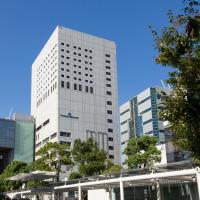 a tall white building in the middle of a city at Kawasaki Nikko Hotel
