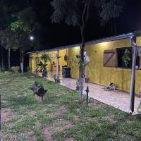 a yellow house with two dogs sitting in front of it at Pousada Sitio do Terrao, Três Marias