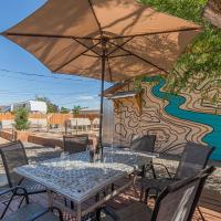 a table with an umbrella in front of a mural at Topo House - Artsy Getaway for Mountain Bikers!, Fruita
