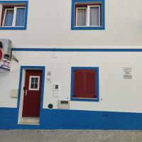 a blue and white building with red doors and windows at Casa de Porto Covo Guest House