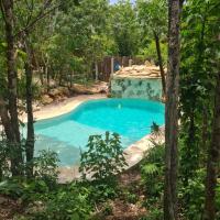 a swimming pool in the middle of a forest at Aldea Yuyu, Tulum