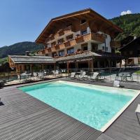 a hotel with a swimming pool in front of a building at Les Ecureuils, Le Grand-Bornand