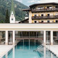 a building with a swimming pool in front of it at Hotel Bräu, Zell am Ziller