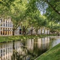 a river in a city with trees and a building at Hotel Kö59 Düsseldorf - Member of Hommage Luxury Hotels Collection