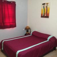 a bedroom with a purple bed with a red curtain at Hotel Kavana, Ouagadougou