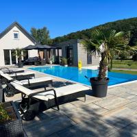 a pool with lounge chairs and a palm tree next to a house at Feriendomizil Schleich im Thermenland, Bad Gleichenberg