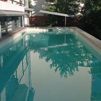 a swimming pool with blue water in front of a house at Studio2 4 impasse camelias, Mamoudzou