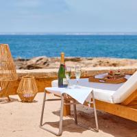 a table with a bottle of champagne and a chair on the beach at Universal Hotel Cabo Blanco - Adults Only, Colònia de Sant Jordi